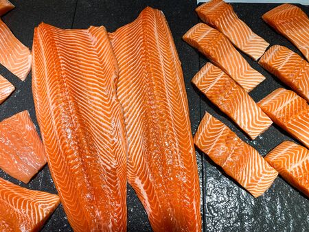 Raw salmon fish fillet on black backgroundの写真素材
