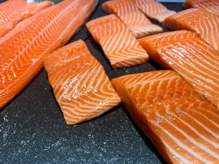 Raw salmon fish fillet on black backgroundの写真素材