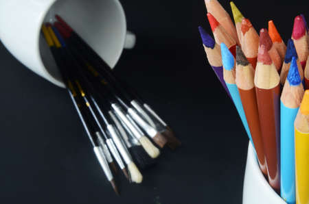 color pencils, paint brushes and watercolor palette,  back to school material, back to school, color pencils on dark backgroundの写真素材