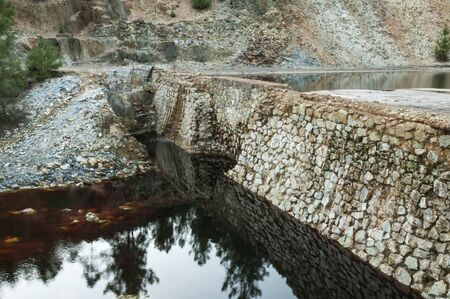 Old abandoned iron mine infrastructure water containment dams with natural light oreの写真素材