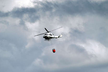 Helicopters engaged in extinguishing a forest fireの写真素材