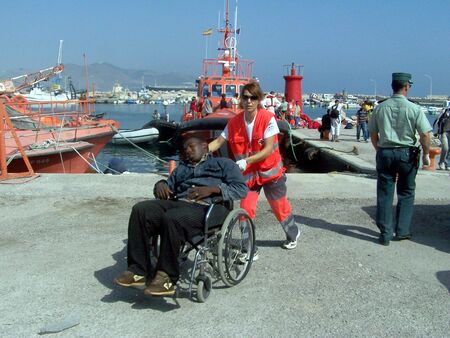 2007/08/22- Motril - Granada - Spain - Patera of illegal immigrants on their arrival at the port of Motril, accompanied by Red Cross and Civil Guardのeditorial素材