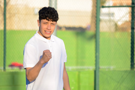 Young athlete celebrating his victory after a paddle tennis matchの写真素材