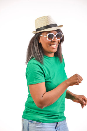 Happy woman dancing and smiling, wearing sunglasses and a hat on white backgroundの写真素材