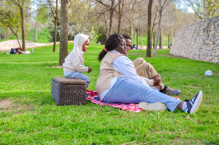 Parents and child having a picnic in a park during a spring dayの写真素材