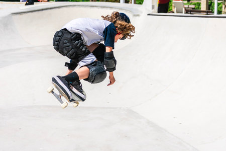 Young boy performing a jump on his skateboard at the skateparkの写真素材