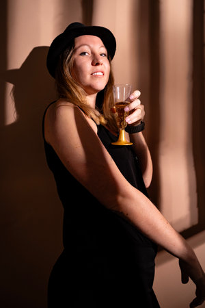 Confident woman smiling, holding a glass of sparkling wine during a festive evening