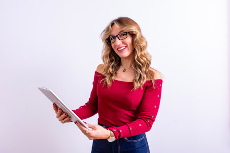 Happy woman reading or working on a tablet with a white backgroundの写真素材