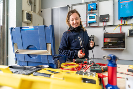 Woman engineer smiling while connecting wires in an off-grid solar power system