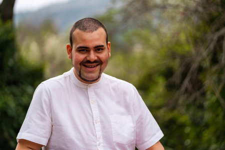 Happy man smiling, showing confidence and individual style in a natural settingの写真素材