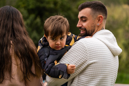 Father holding his young son, enjoying a family outing outdoorsの写真素材