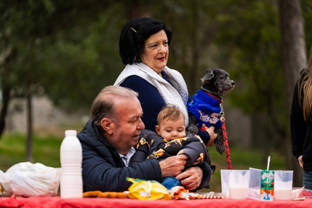 Grandparents, baby, and pet dog bonding together during an outdoor family gathering