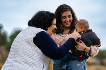 Grandmother, mother, and baby laughing, bonding, and connecting with joy and affection