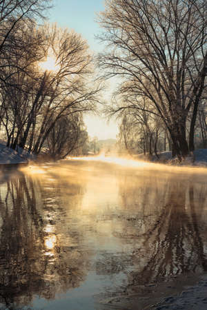 Winter beautiful landscape. Steam rising above the water on the frosty Sunny day.の写真素材