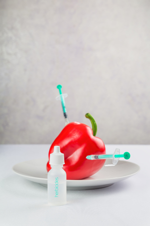 fresh juicy red peppers on a plate, treated with chemicals
