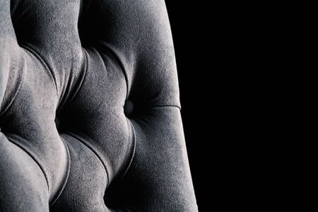 fragment of gray suede armchair on black backgroundの写真素材