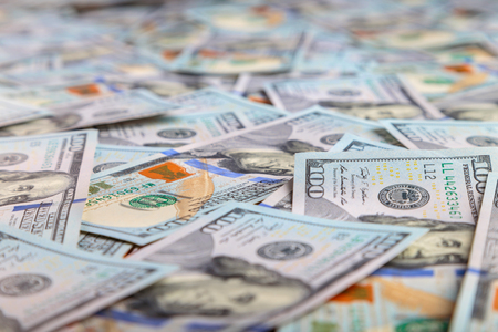 Paper 100 dollar bills spread out on the plane in a chaotic mannerの写真素材