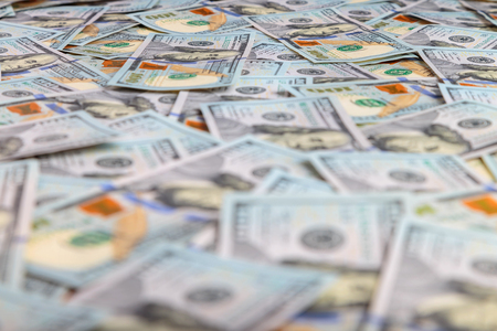 banknotes of 100 dollar bills spread out on the plane in a chaotic mannerの写真素材