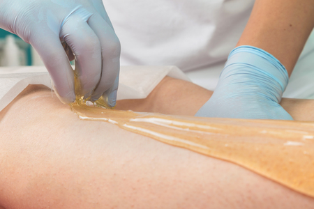 Removing unnecessary hair on the legs. Procedure sugaring in a beauty salon.Depilatory sugar pasteの写真素材