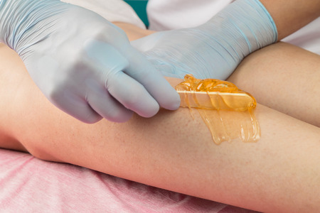 Removing unnecessary hair on the legs. Procedure sugaring in a beauty salon.Depilatory sugar pasteの写真素材