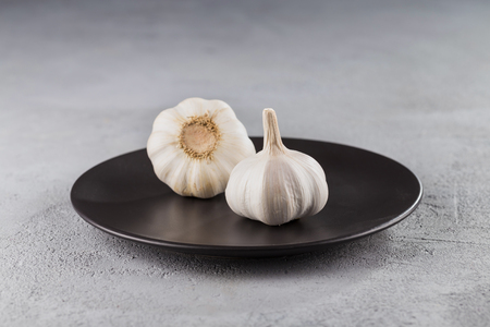 Garlic heads close-up on grey background. Condiment.の写真素材