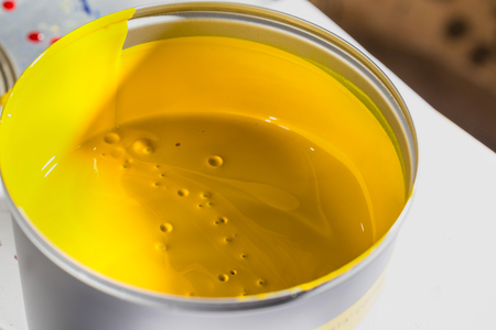 Open jar with yellow printing ink. CMYK printing ink.の写真素材