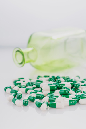 pile of green-white color medical pills on white backgroundの写真素材