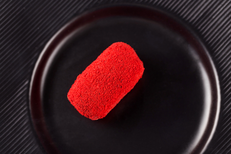 miniature cake-potatoes with red sprinkles on a black plate. Top view.の写真素材