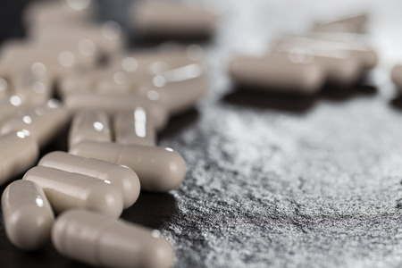 Close-up pile of white color medical pills on black backgroundの写真素材