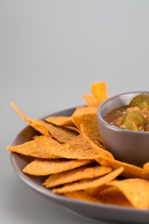Nachos on a plate with hot sauce. Mexican appetizer.の写真素材