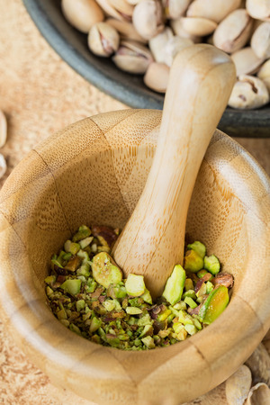 Peeled pistachios, crushed into pistachio crumbs in a hand-made wooden mortar.の写真素材