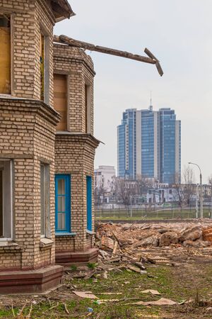 Slums on the background of a modern high-rise building. Demolition of old dilapidated buildings and clearing for the construction of modern buildings in Minsk, Belarus 07.04.2019.のeditorial素材