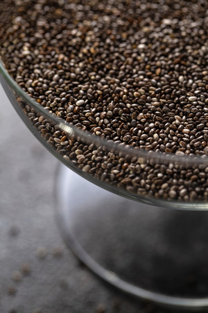 Chia seeds in a glass vase close-up. The texture of the seeds. Verticalの写真素材