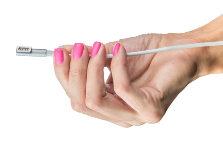 Electric cable for charging gadgets in a graceful female hand with a beautiful manicure isolated on a white backgroundの写真素材