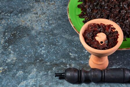 Shisha in a clay bowl stands on the background of a beautiful plate with a Smoking mixture. Traditions of hookah Smoking.の写真素材
