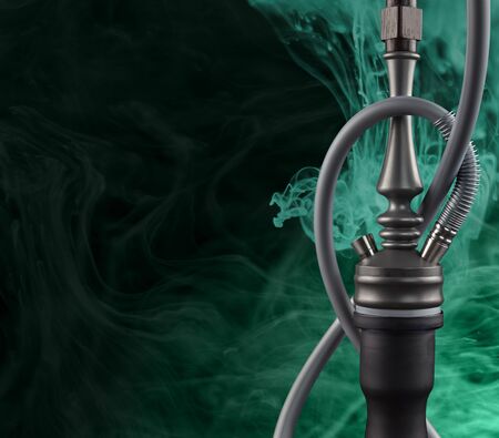 Modern hookah shrouded in mysterious aqua menthe smoke on a black background with a place for text.