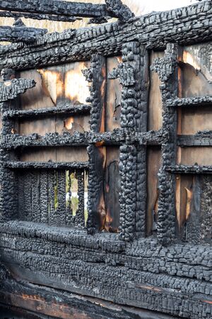 Fragments of the interior of an apartment in a wooden house that burned down as a result of a fire. Charred wooden beams.の写真素材