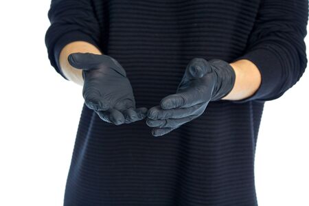 Outstretched hands in black latex gloves of a beautiful slender girl in black clothing, isolated on...
