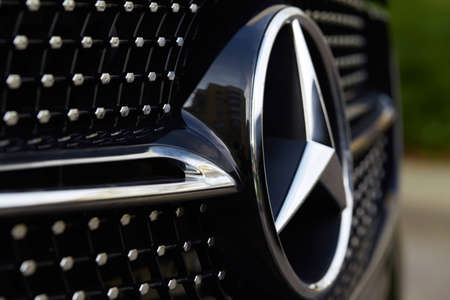 Close-up of a Mercedes Benz fragment with the logo in the form of a star, framed by chrome elements...