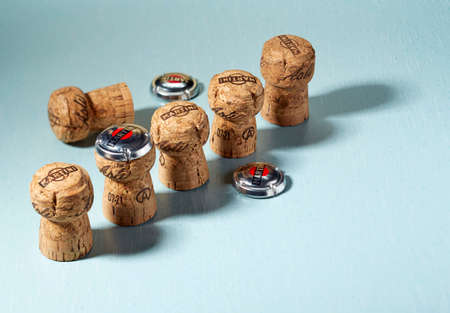 Five wooden Asti Martini champagne corks, arranged diagonally in a row, stand on the bluish surface of the table and one lies behind them. Advertising shooting Minsk, Belarus, 18.04.2022.のeditorial素材