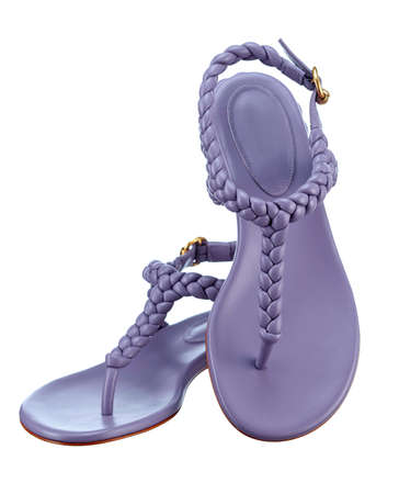 Beautiful pair of elegant womens summer sandals made of purple leather with braided leather straps on a low heel, highlighted on a white background. Vertical. The trend of the summer season.の写真素材