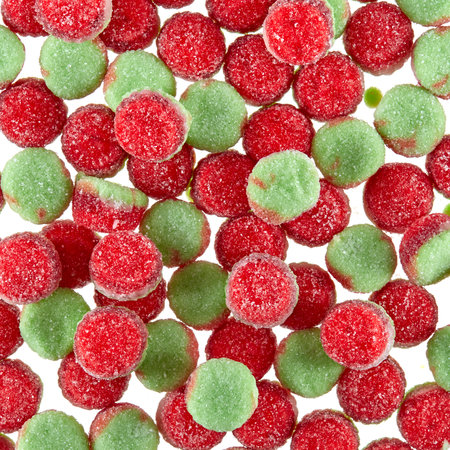 Texture of randomly scattered gelatin candies of red-green colors, in the form of buns sprinkled with sugar.の写真素材