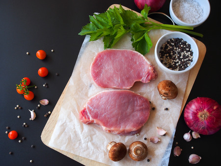Raw pork chop steak prepare in kitchen with vegetable and spices for food and cooking concept.の写真素材