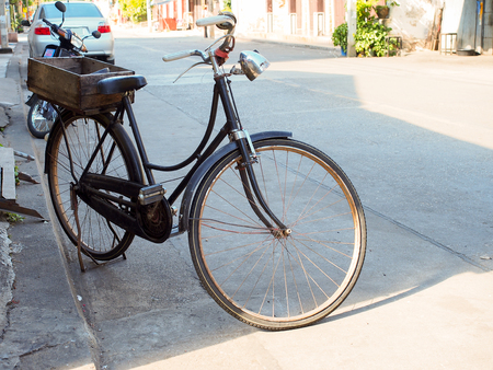 Vintage black bicycle parking on road for energy saving conceptの写真素材