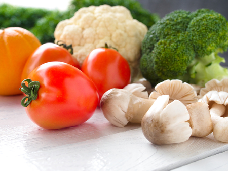 Tomato,mushroom,broccoli and cauliflower vegetables on white wooden table for healthy food concept.の写真素材