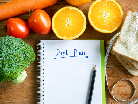Diet plan notebook and vegetables with copy space for healthy food concept.の写真素材