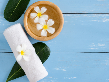spa products,white towel with Plumeria flower and leaf  on blue wooden table with copy space.の写真素材