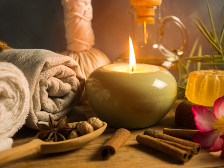 spa massage items,aroma oil,herbal compress ball,soap  and towel in candlelight.の写真素材