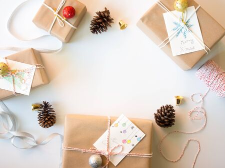 Christmas concept, brown gift boxes with card ,pine cones,golden bell and glister ball on white background in top view with copy space in center.の写真素材