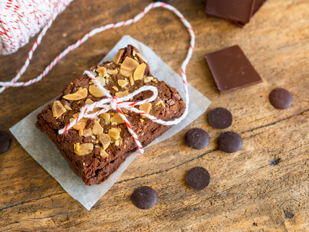 Fudge brownies chocolate cake topping with almond sliced on wooden table for winter bakery concept.の写真素材